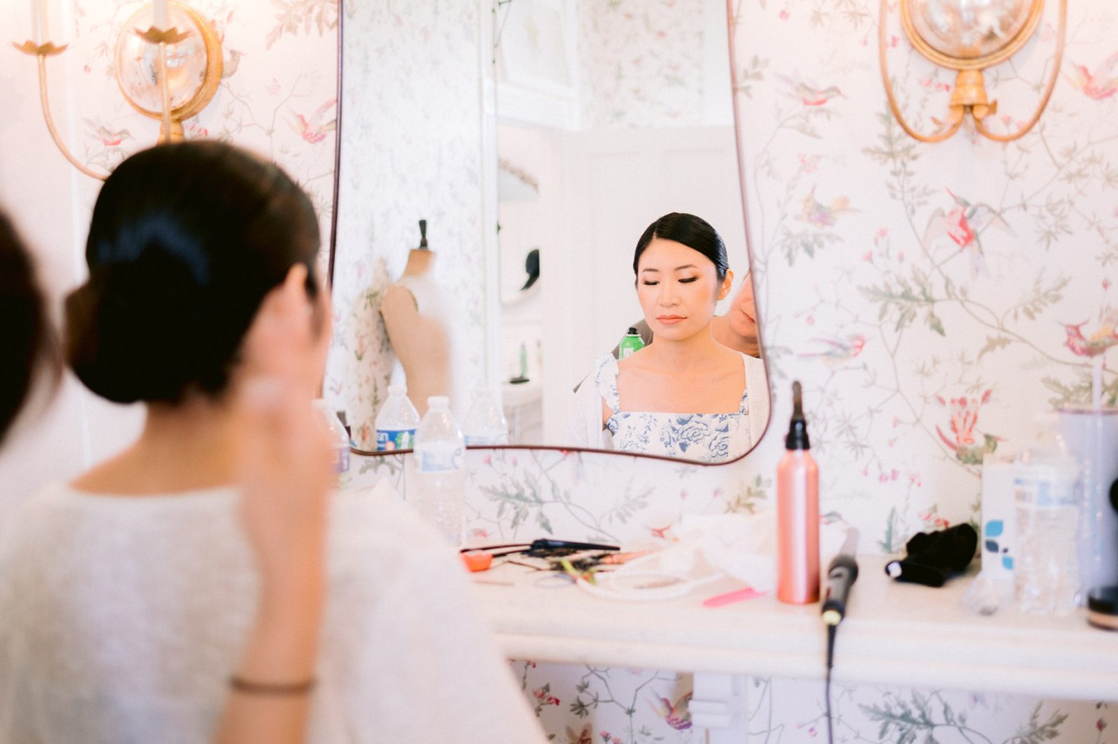 bride getting ready in front of mirror, bride putting on makeup, woodbine mansion bridal suite, woodbine mansion wedding, woodbine mansion wedding details, classic austin wedding, mansion wedding venues near austin, historical wedding venue, best austin wedding venues, austin wedding photographer, hill country wedding, round rock wedding venue