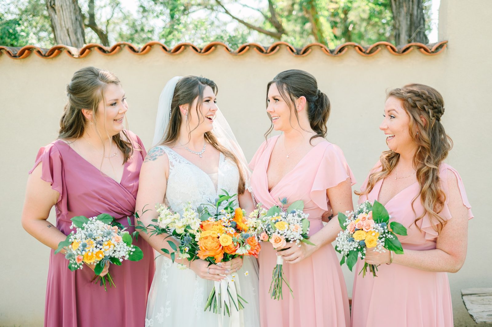 bride and bridesmaids laughing, tilted tulip florals, austin wedding, tuscan hall, chapel dulcinea wedding venues, tuscan hall and veranda room, tuscan hall wedding venue, austin wedding, austin wedding photography, hill country wedding, unique austin wedding venue, veranda room, chapel dulcinea, wizards guest room, wizard academy wedding venue, free austin wedding venue