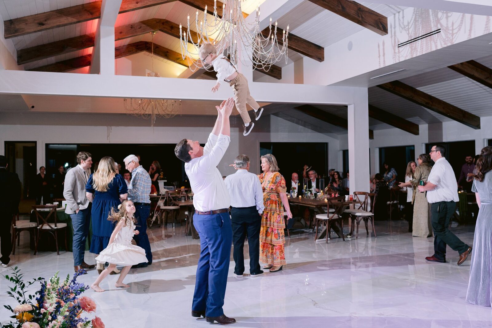 groom throwing ring bearer in the air, reception dancing, guests dancing at wedding, videre estate reception space, wedding at the videre estate venue, wimberley, 
