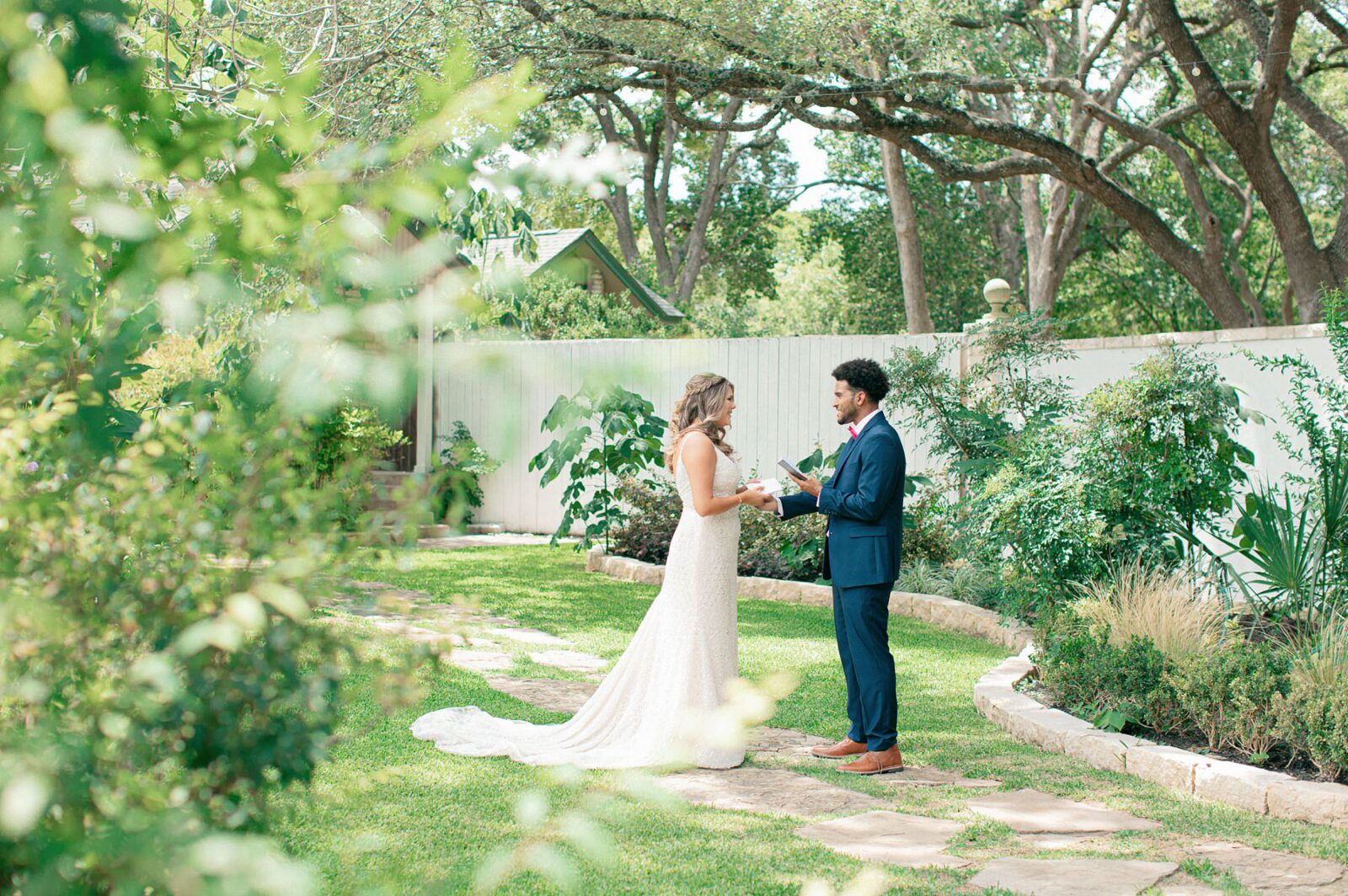 bride and groom reading vows privately during first look at austin garden wedding venue